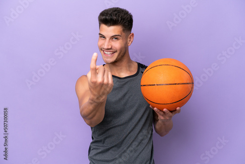 young caucasian woman basketball player man isolated on purple background doing coming gesture
