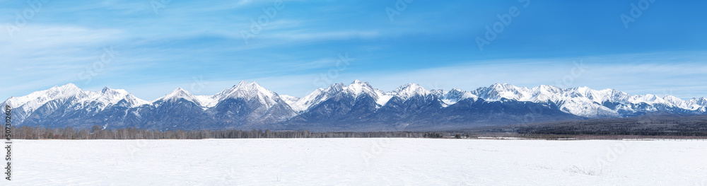 Winter landscape panorama with Sayan Mountains in Siberia on sunny winter day. Natural background.