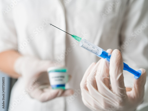 Close up on injection in doctors hand with white gloves