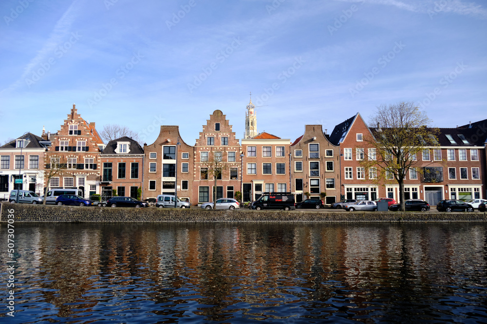 Haarlem, Netherlands - April 12. 2022: Panoramic view of traditional Dutch houses lining the river Sparne in springtime.