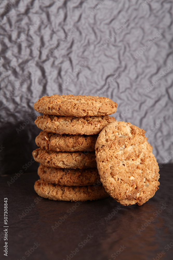 Oatmeal, fig, hazelnut, pistachio and sesame cookies on a black background. Enjoyable snack. Oatmeal, fig, hazelnut, pistachio and sesame cookies on a black background. Enjoyable snack.