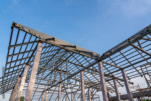 Roof structure of steel for building or house under construction on sky background.