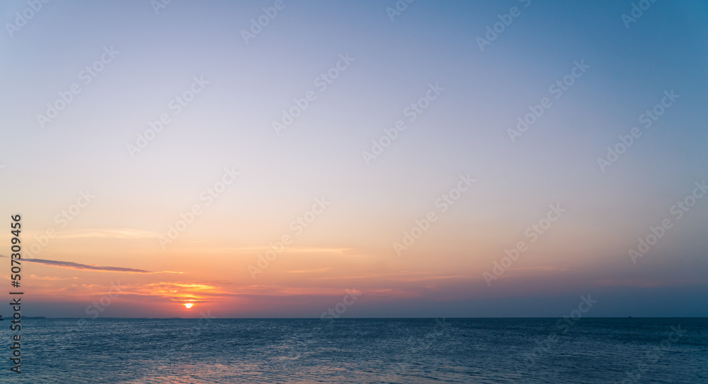 Obraz premium Dusk sky over sea in the evening with orange sunlight and sundown 
