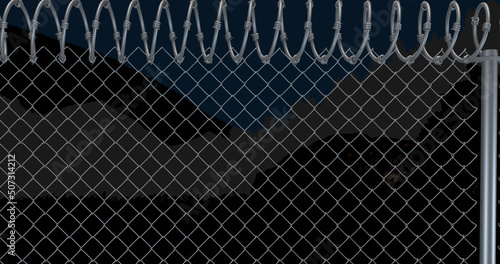 Image of fence with barbed wire over view of mountains