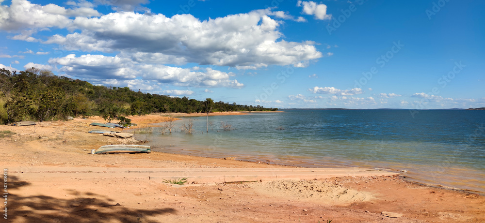 Linda vista de parte da represa de três marias, com água límpida, céu azul com nuvens e algumas lanchas na marchem, na região de Três Marias, Minas Gerais, Brasil.