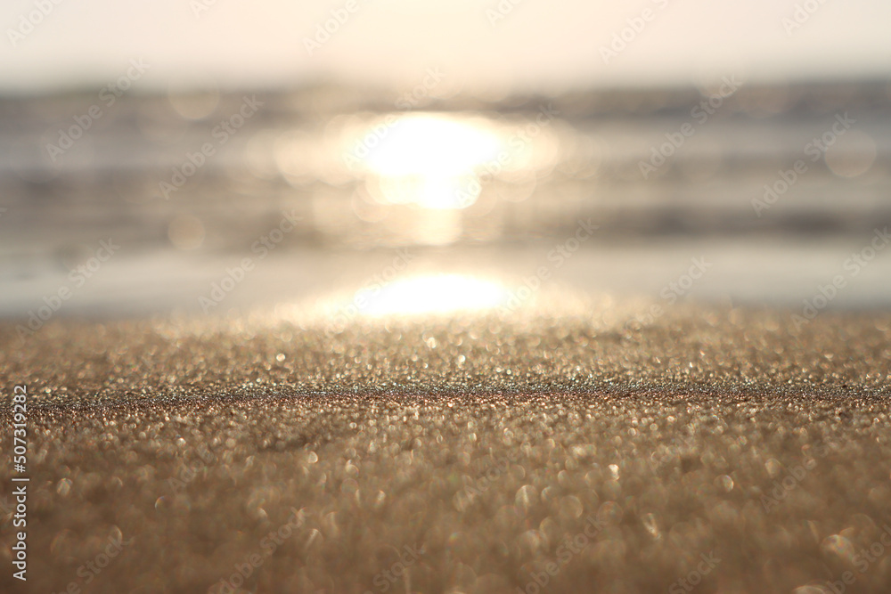 Obraz premium Sea waves and warm sunset light, calm and relaxing sandy beach