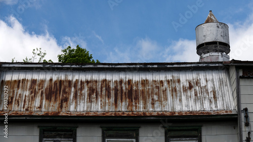 A rusty barn roof on a blue sky