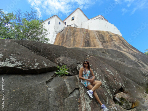 Mulher encostada em rochas aos pés do Convento da penha, Vitória no estado do Espírito Santo, Brasil. photo