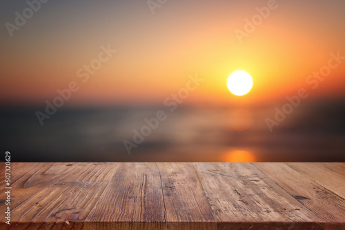 Fototapeta Naklejka Na Ścianę i Meble -  Wooden table and blurred sunset background. Summertime and vacation