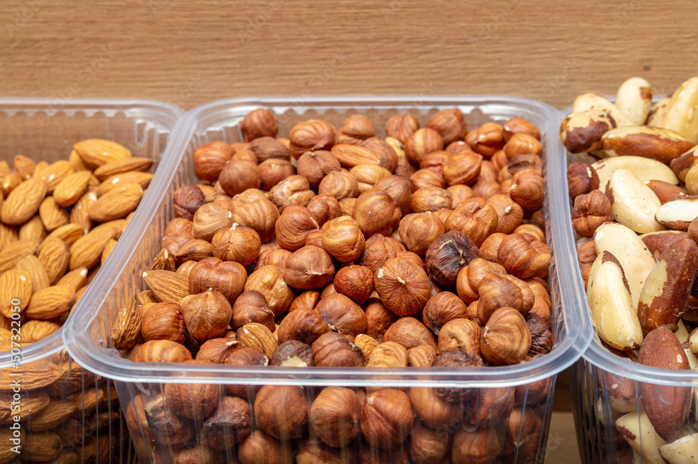 hazelnuts in a plastic container next to other nuts hazelnuts in a plastic container next to other nuts
