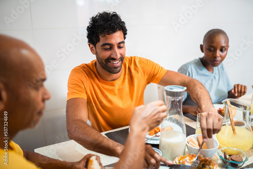 Homem tomando café da manhã com a família