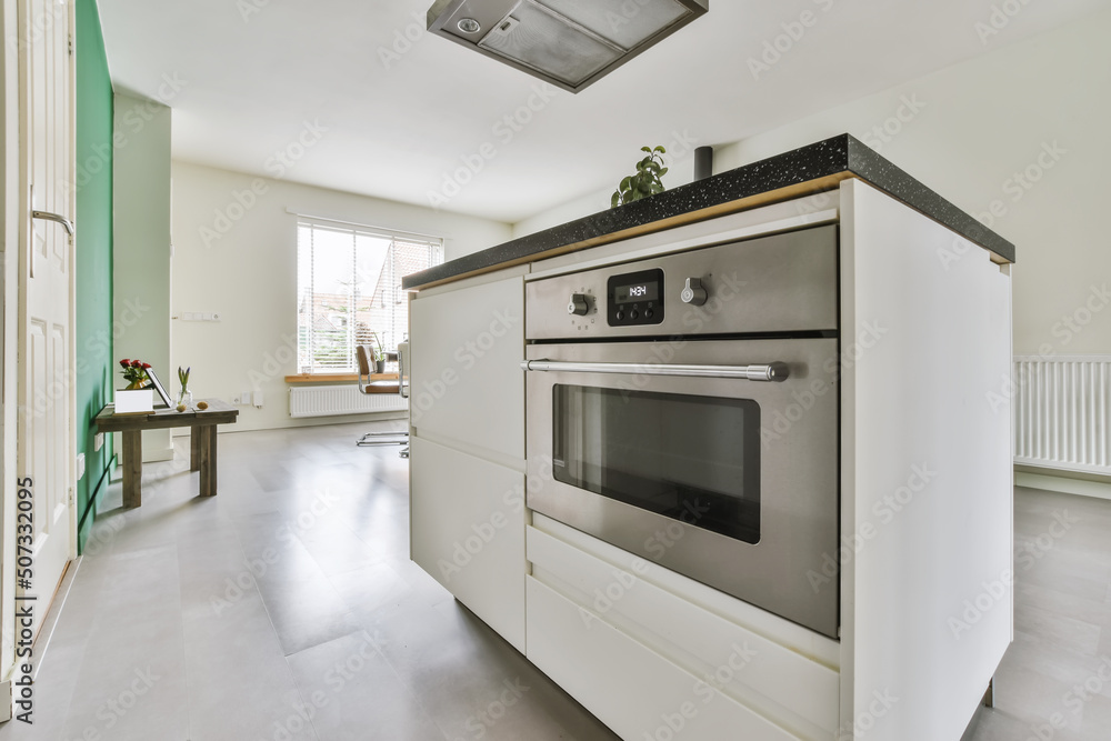 White kitchen interior with built in oven in daylight White kitchen interior with built in oven in daylight