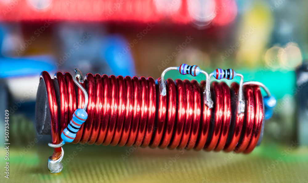 Electronic coil with ferrite core and blue small color coded resistors on red copper wire. Cylindric electromagnetic inductor on PCB detail of cable TV amplifier with colored bokeh in blur background. - obrazy, fototapety, plakaty 