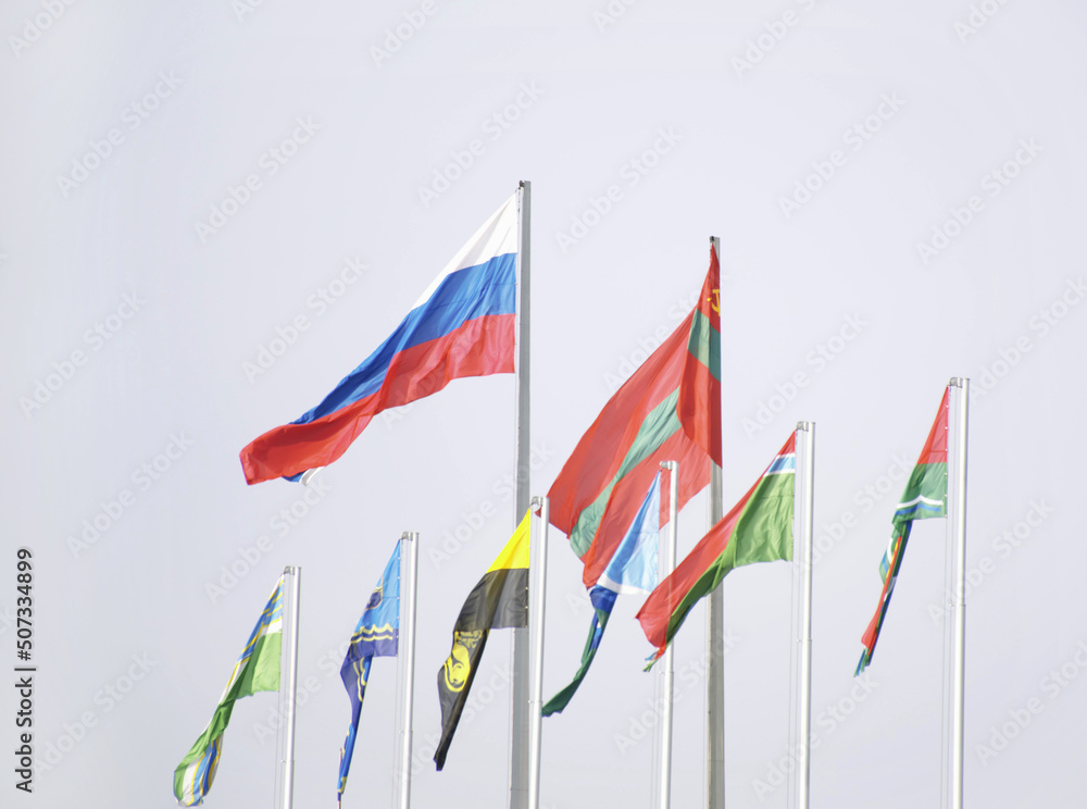 Obraz na płótnie national flag of Transnistria and Russia against the sky. below small flags of cities and regions of Transnistria w salonie