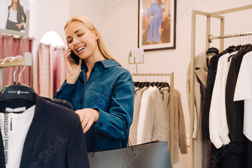 Young beautiful blonde woman shopping and talking on the phone