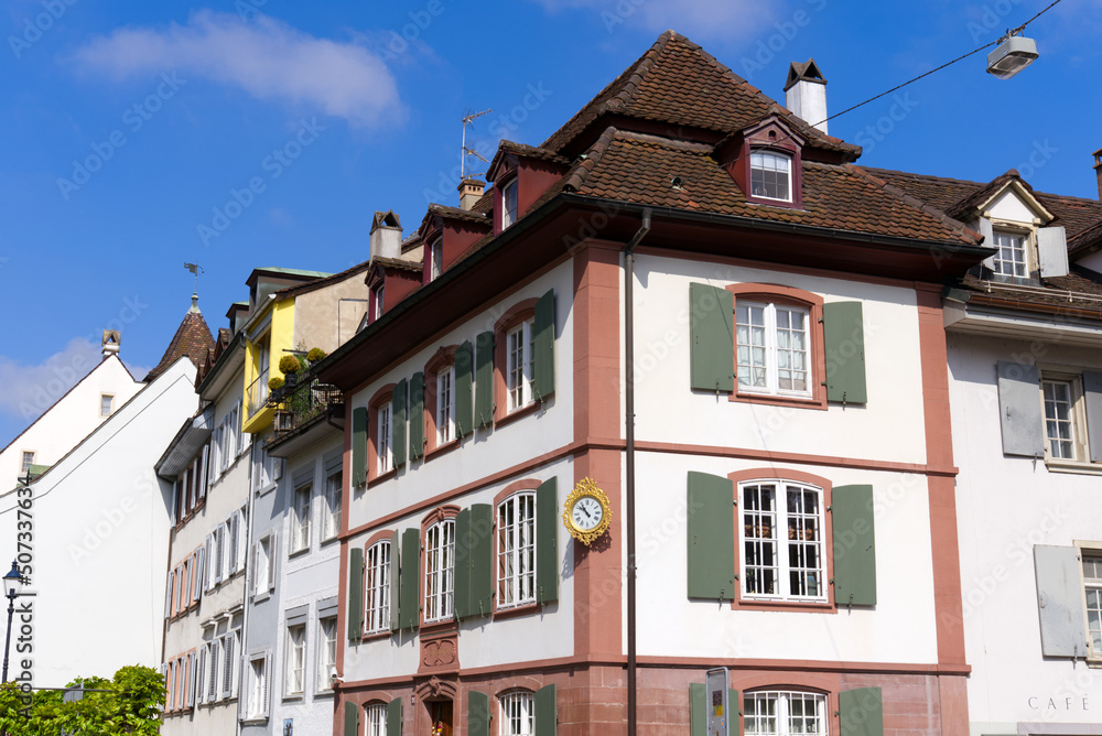 Medieval old town of City of Basel with beautiful historic houses and house named Zum Grabeneck 1776 with golden clock on a blue cloudy spring day. Photo taken April 27th, 2022, Basel, Switzerland.