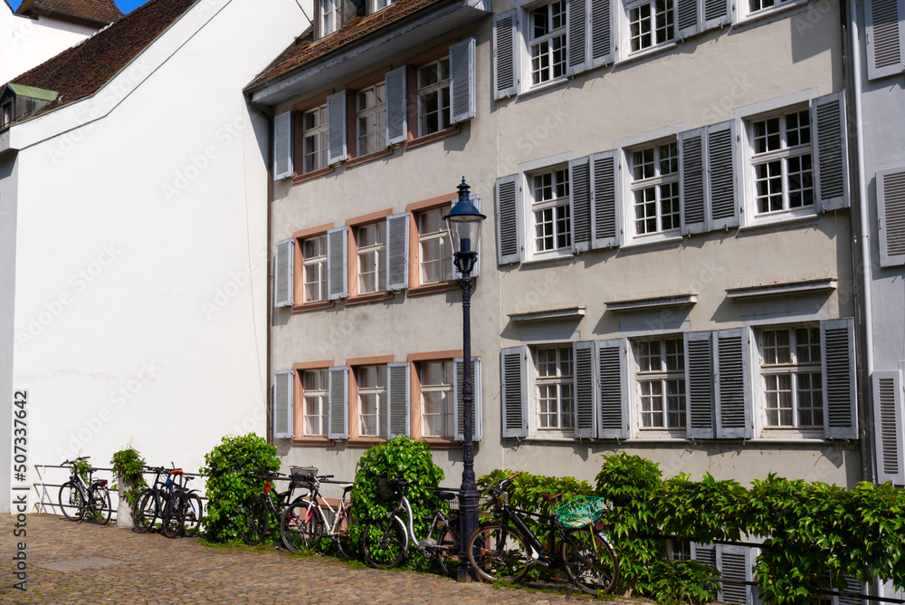 Fototapeta premium Medieval old town of City of Basel with beautiful historic houses and parked bicycles on a blue cloudy spring day. Photo taken April 27th, 2022, Basel, Switzerland.