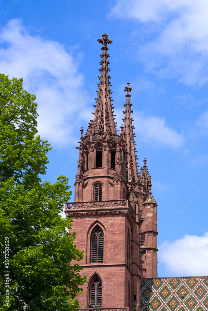 Twin tower of medieval church Basler Minster at the old town of Basel on a blue cloudy spring day. Photo taken April 27th, 2022, Basel, Switzerland. Twin tower of medieval church Basler Minster at the old town of Basel on a blue cloudy spring day. Photo taken April 27th, 2022, Basel, Switzerland.