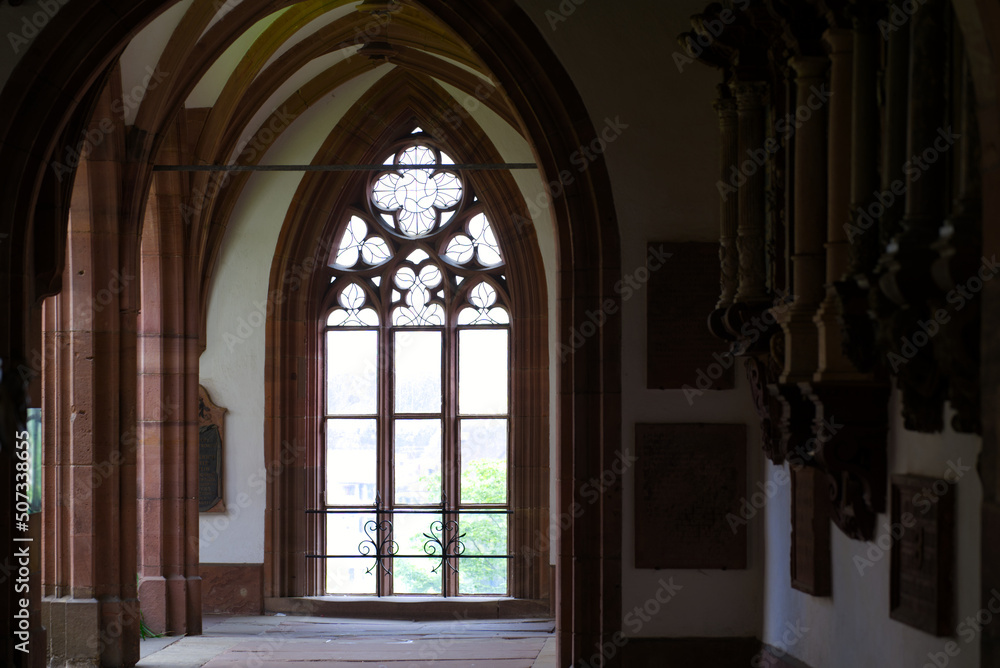 Beautiful window at cloister of Basler Minster at the old town built with red sandstone on a blue cloud spring day. Photo taken April 27th, 2022, Basel, Switzerland.