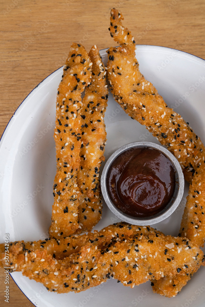 Rustic American food. Top closeup view of fried chicken sticks breaded
