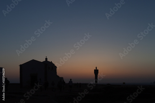 silhouettes of houses and people at sunset over the atlantic ocean from the portuguese fortress of Sagres 