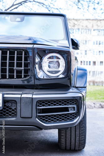 front view of the headlight of a large black powerful prestigious car