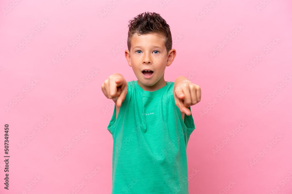Little caucasian boy isolated on pink background surprised and pointing front Little caucasian boy isolated on pink background surprised and pointing front