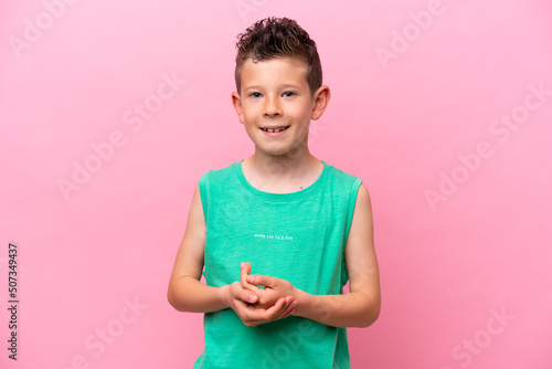 Little caucasian boy isolated on pink background laughing