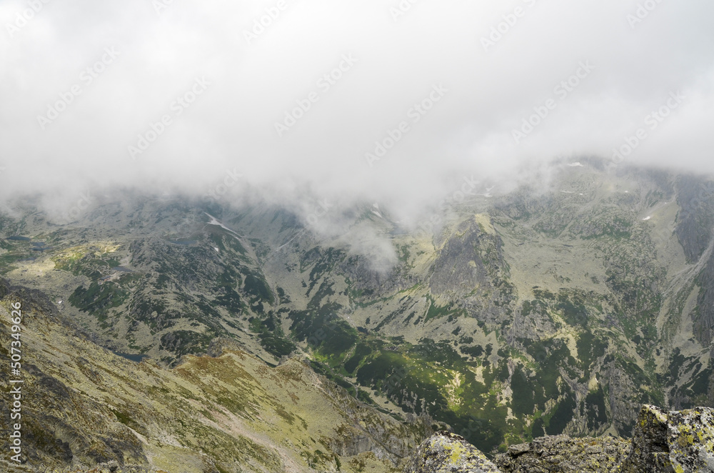 Fog and clouds over high peaks of mountain ridge in National Park High Tatras Mountains, Slovakia 