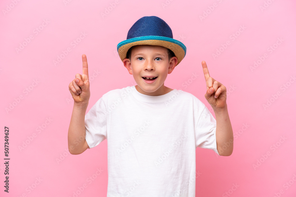 Little caucasian boy wearing a hat isolated on pink background pointing up a great idea Little caucasian boy wearing a hat isolated on pink background pointing up a great idea