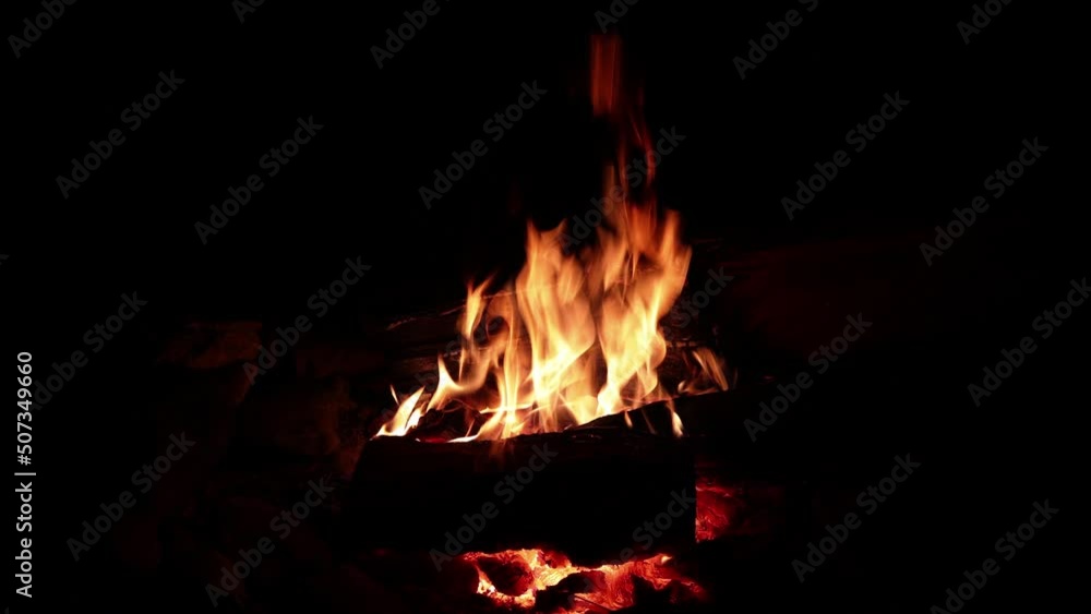 Orange flames of a campfire close-up. Tongues of flame move over the firewood. Horizontal video of nature. High quality 4k footage Orange flames of a campfire close-up. Tongues of flame move over the firewood. Horizontal video of nature. High quality 4k footage