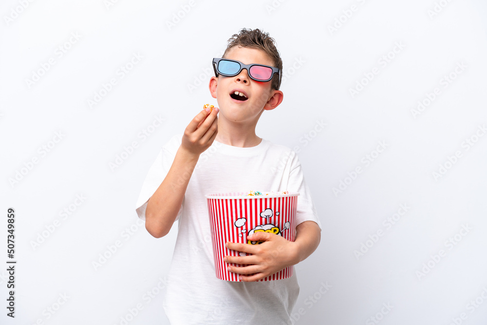Little caucasian boy isolated on white background with 3d glasses and holding a big bucket of popcorns Little caucasian boy isolated on white background with 3d glasses and holding a big bucket of popcorns