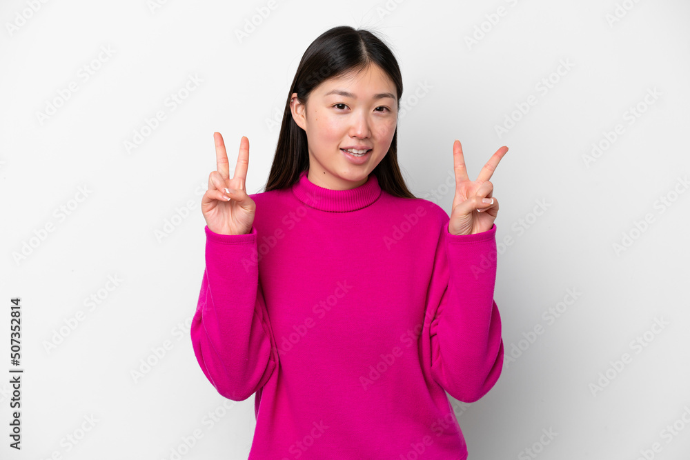 Young Chinese woman isolated on white background showing victory sign with both hands