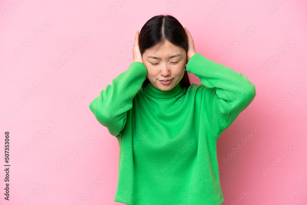 Young Chinese woman isolated on pink background frustrated and covering ears Young Chinese woman isolated on pink background frustrated and covering ears