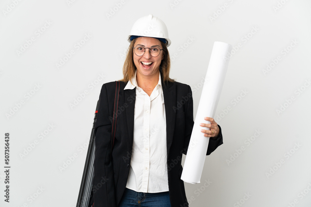 Middle age architect woman with helmet and holding blueprints over isolated background with surprise facial expression Middle age architect woman with helmet and holding blueprints over isolated background with surprise facial expression