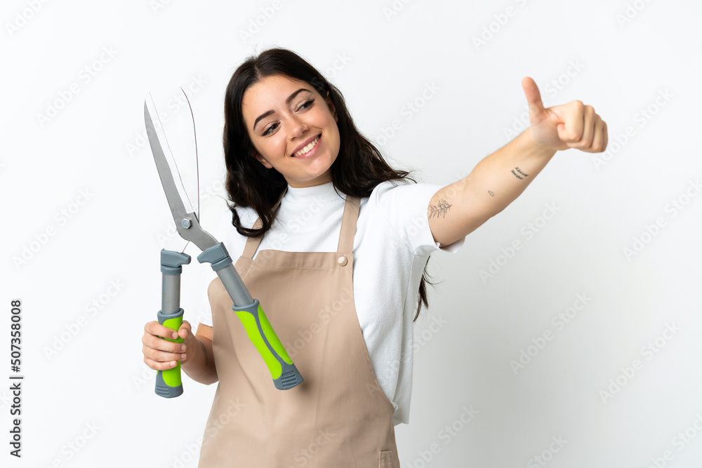Young caucasian woman holding a plant isolated on white background giving a thumbs up gesture Young caucasian woman holding a plant isolated on white background giving a thumbs up gesture