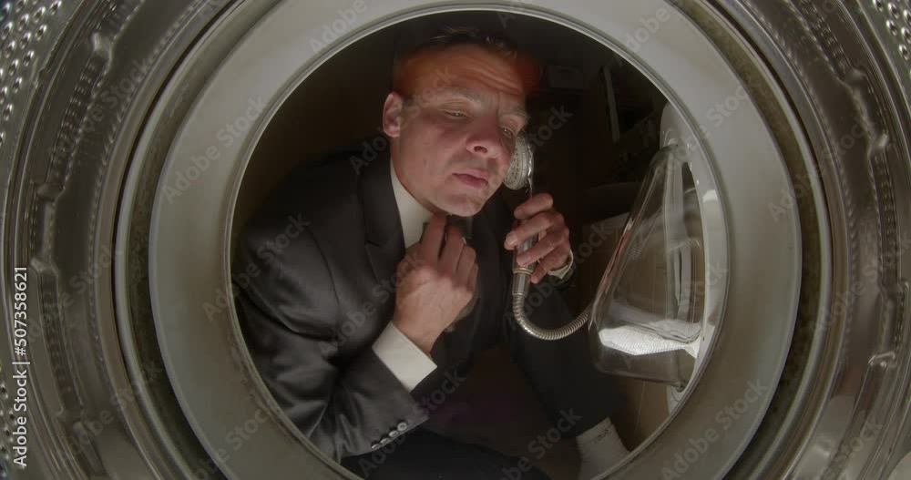 Crazy man imitates talking on the phone using a shower faucet, humorous psychotic condition with hallucinations like delirium tremens. Absurd situation laughably foolish. Funny portrait of businessman Crazy man imitates talking on the phone using a shower faucet, humorous psychotic condition with hallucinations like delirium tremens. Absurd situation laughably foolish. Funny portrait of businessman