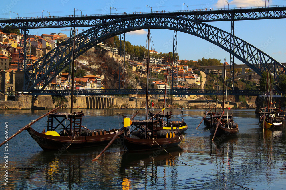 Bridge Ponte Luis I over the river Douro and typical Portuguese boats with wine barrels in the city of Porto, in the north of Portugal