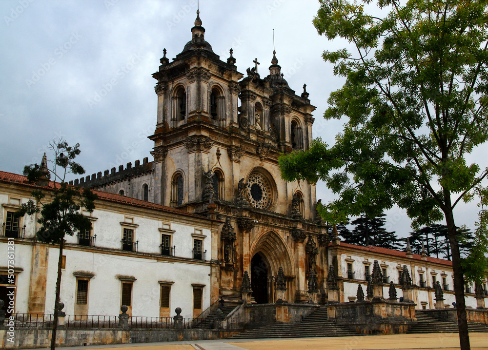 Gothic building of the Alcobaça Monastery against the backdrop of the stormy sky in the town of Alcobaça, in western Portugal