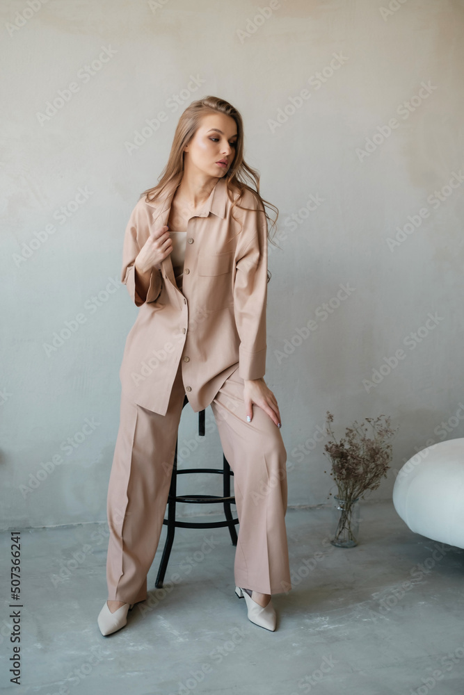 Naklejka premium Nice girl in pantsuit at concrete wall.