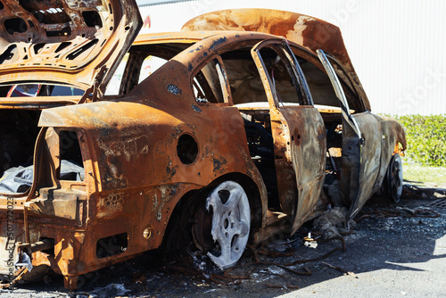 a burned-out car in the parking lot near the visa shop at the back of