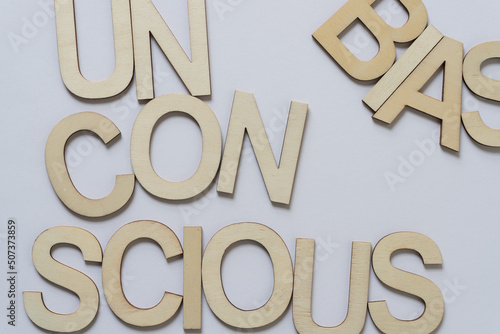 the expression "unconscious bias" in large wooden letters on a light background
