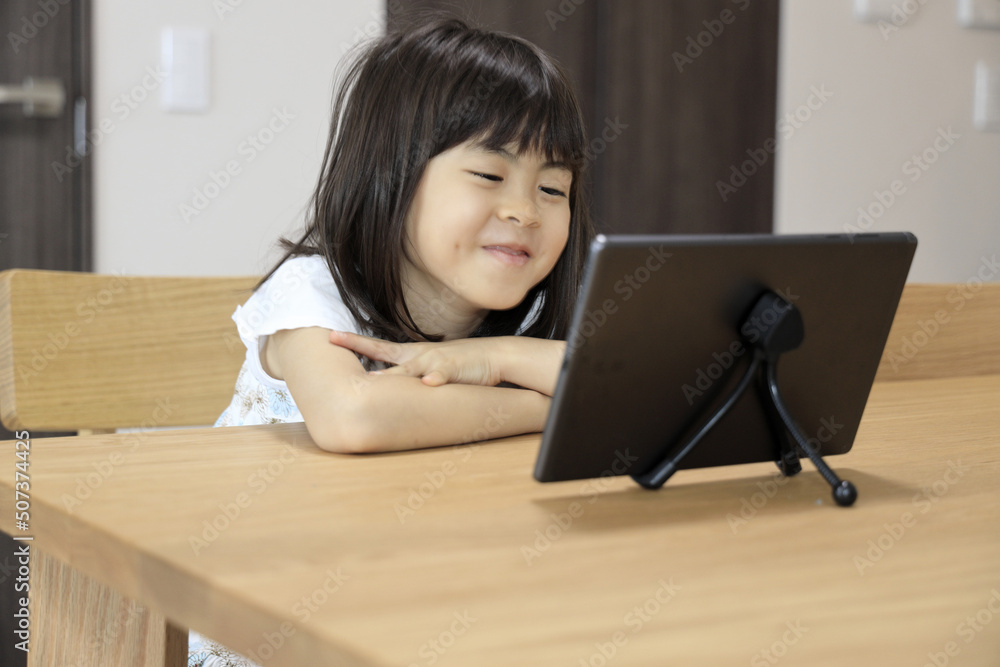 タブレットで動画を見る女子小学生 (7歳)