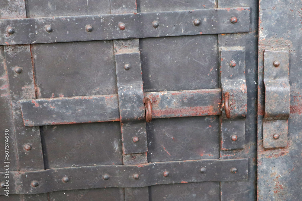 an iron black old rusty door with a lock. lock door an iron black old rusty door with a lock. lock door