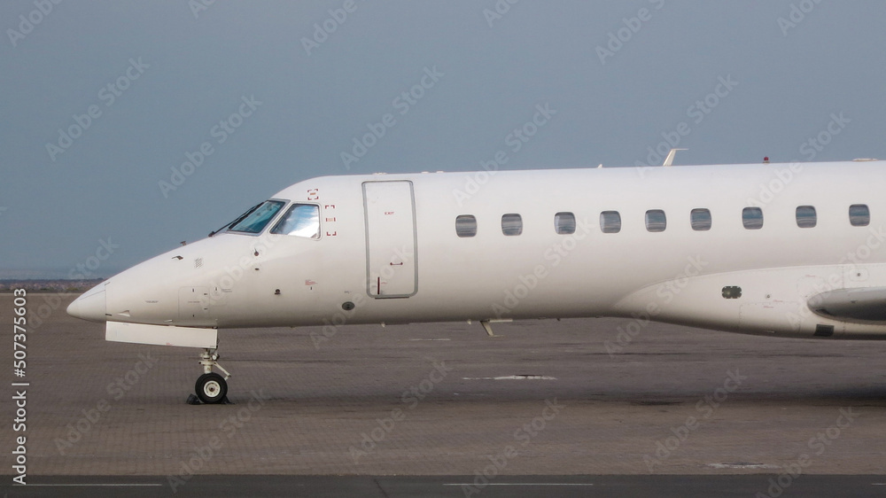 Eine weiße Embraer ERJ 145, ERJ 135 Businessjet auf einem Vorfeld Eine weiße Embraer ERJ 145, ERJ 135 Businessjet auf einem Vorfeld