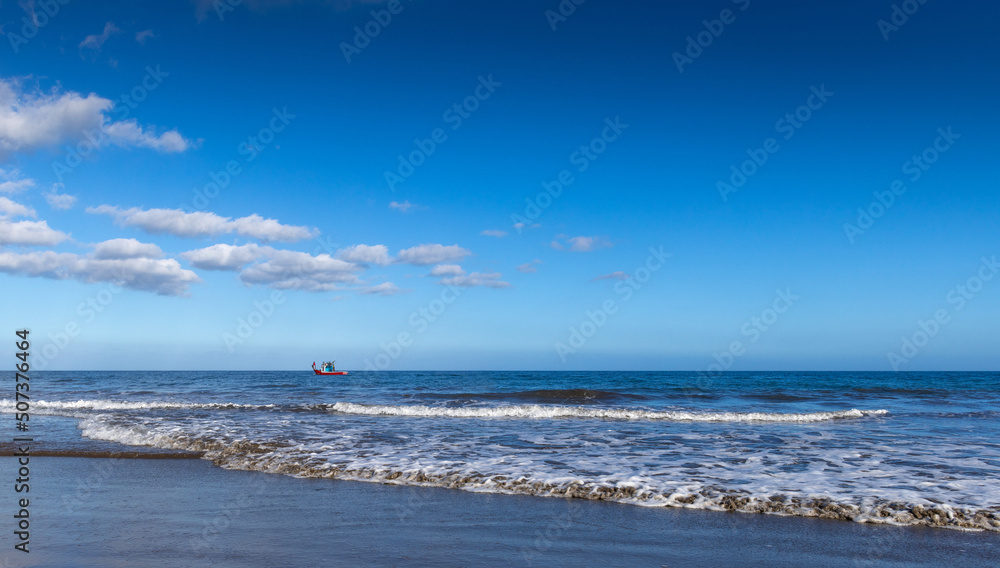 A small boat in the sea and the waves off the shore A small boat in the sea and the waves off the shore