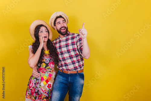 Beautiful couple dressed in typical clothes for a Festa Junina. Arraia de Sao Joao. looked and seeing something distant, wow, incredible. photo