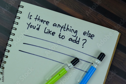 Is there anything else you'd like to add in write on a book isolated on Wooden Table.