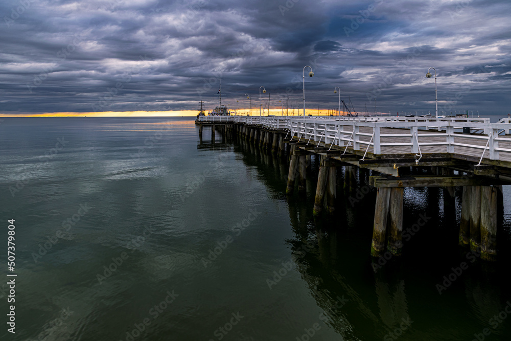 Fototapeta premium Pier on the sea coast and stormy sky