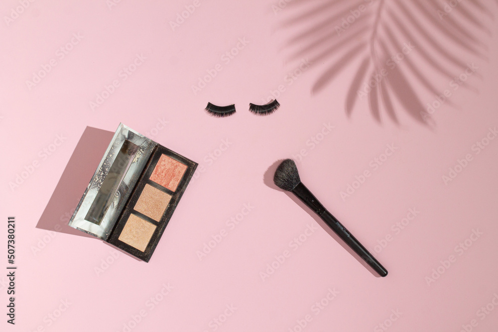 Make up set. Powder brush, eye shadows, fake eyelashes. Palm tree shadow. Beauty and fashion concept. Make up set. Powder brush, eye shadows, fake eyelashes. Palm tree shadow. Beauty and fashion concept.